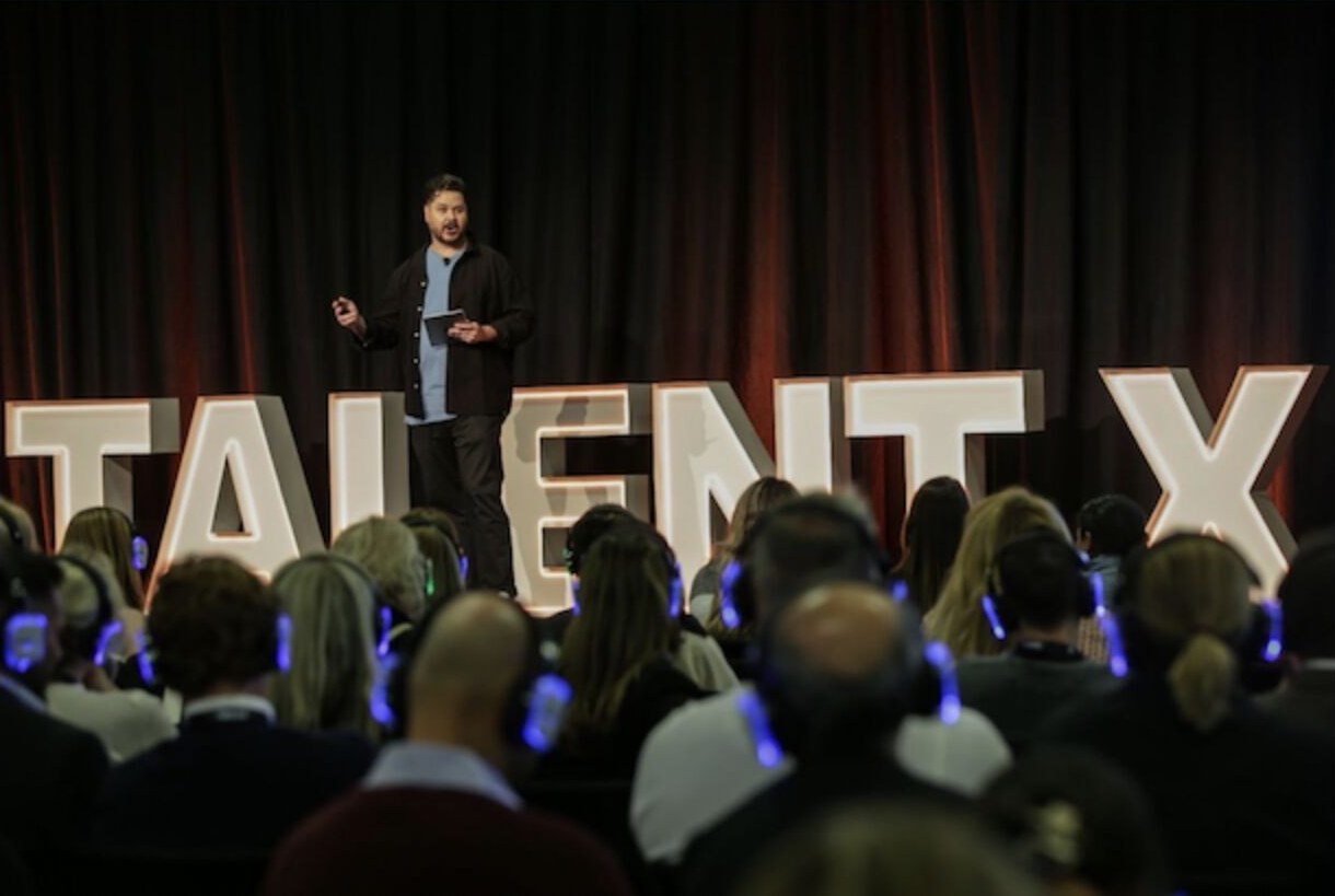 John Bourke on stage at Talent X, speaking on AI and automation in recruitment